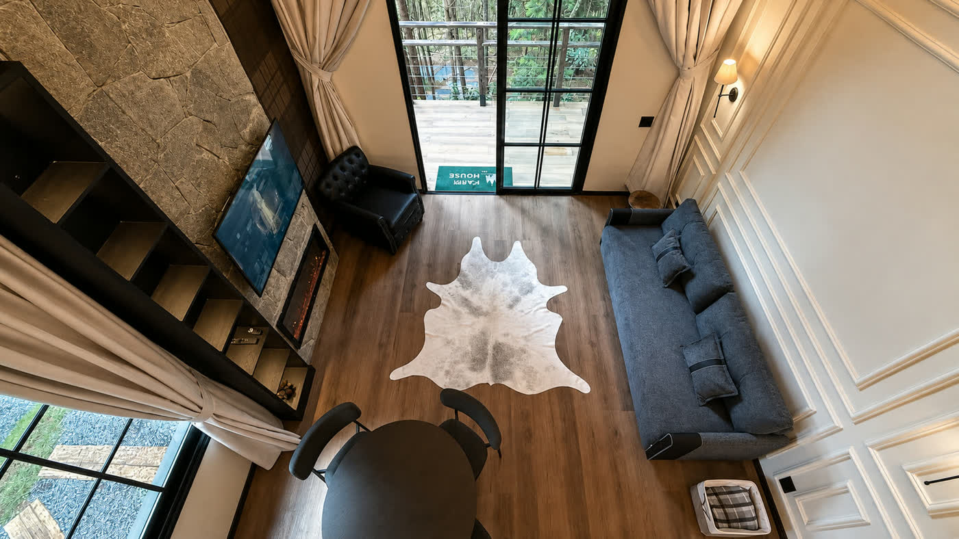 A sala vista de cima, do mezanino, com o tapete de couro e as portas para o deck