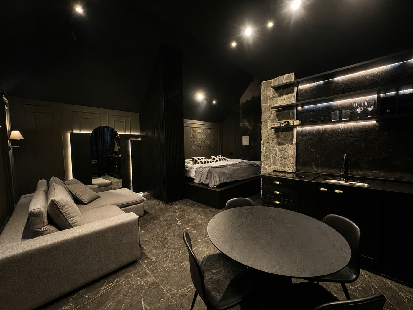 O loft da Mountain House, com sofá, a cama ao fundo e a cozinha